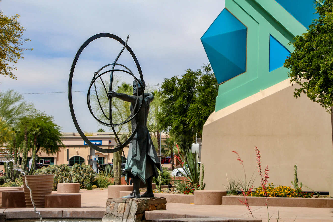 A bronze statue of a figure with concentric circles in a landscaped plaza in Scottsdale