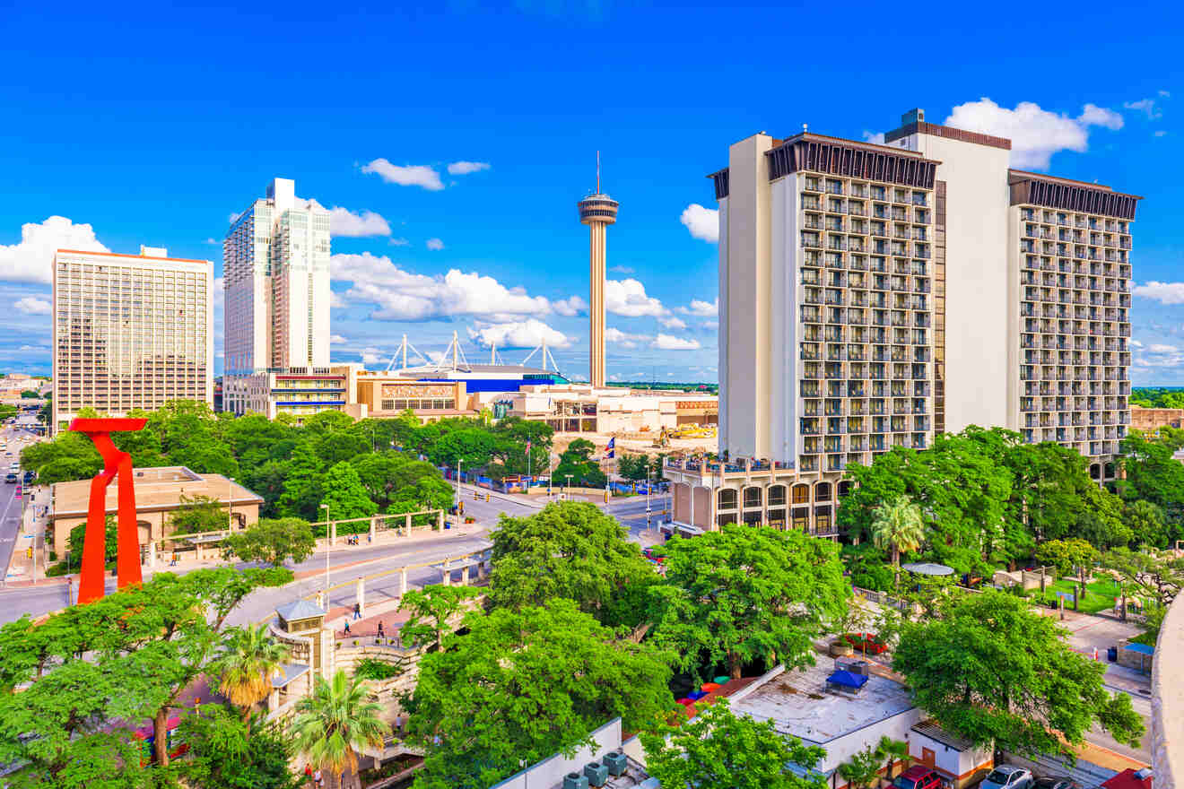 Aerial view of downtown San Antonio featuring the Tower of the Americas, colorful buildings, and a distinctive red sculpture