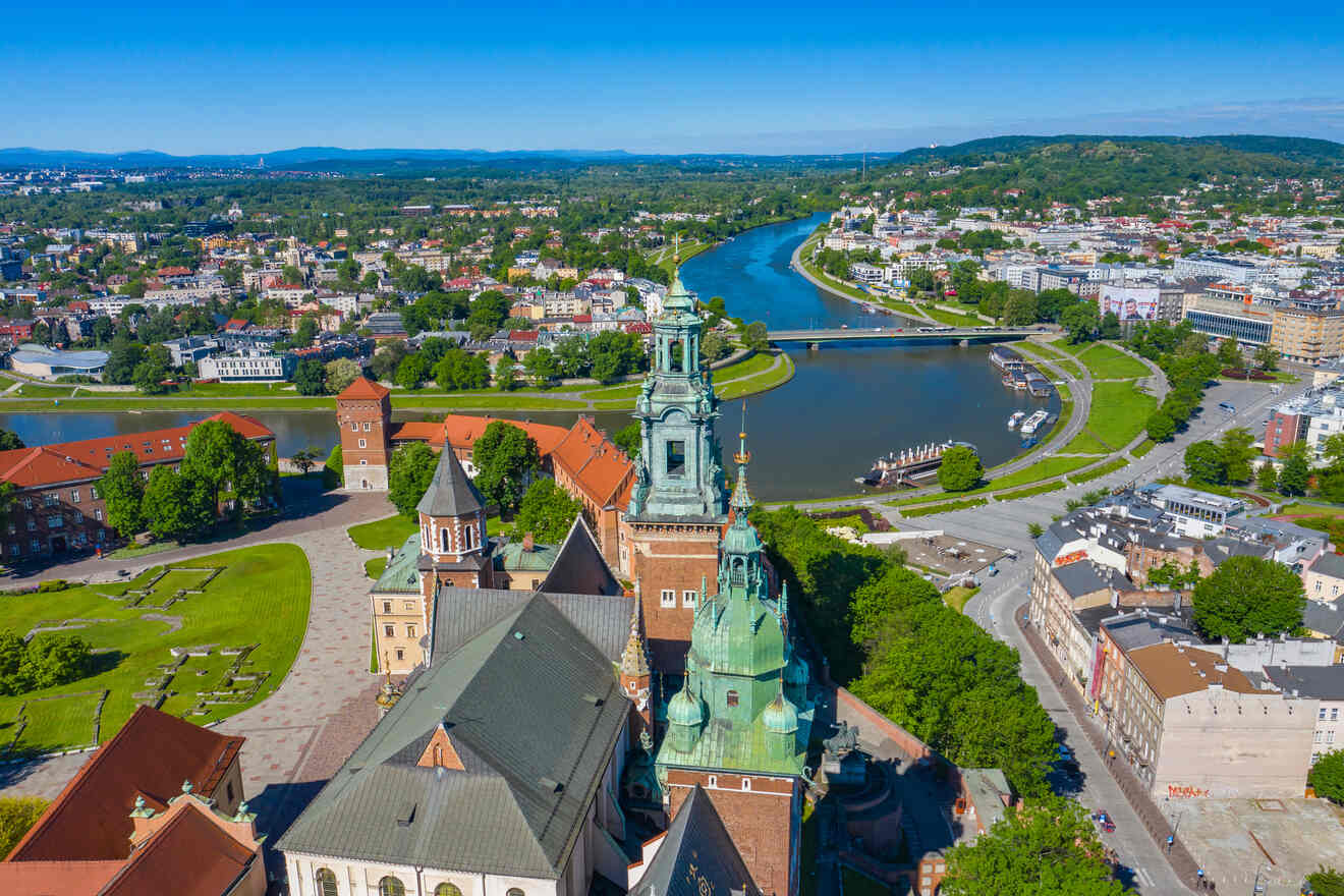 An aerial view of a historic city with a cathedral, a winding river, and surrounding buildings under a clear blue sky.
