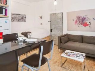 A modern and minimalist studio apartment with a comfortable seating area and an open-plan layout.