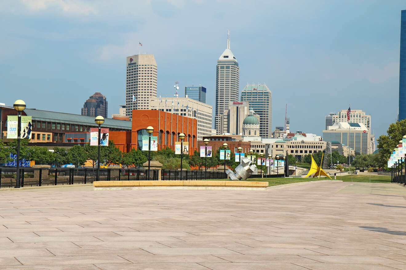 Spacious outdoor plaza with a view of the Indianapolis skyline, featuring various buildings and a bright, clear sky