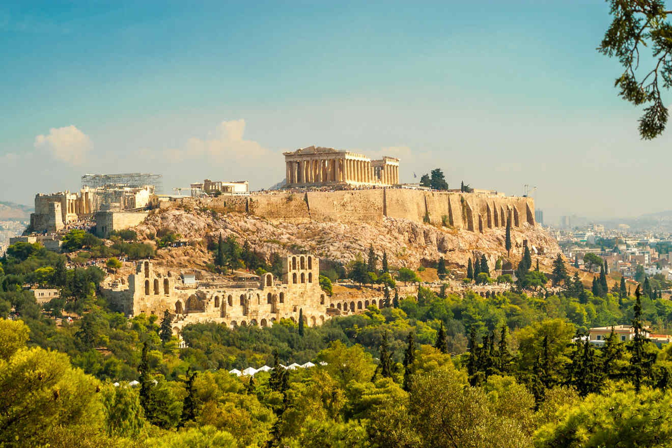 The Acropolis of Athens on a sunny day, showcasing the Parthenon and other ruins, with a view of the city in the background.
