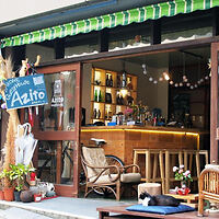 A quaint street-side bar named 'Azito' with an inviting open entrance and wooden interior decor