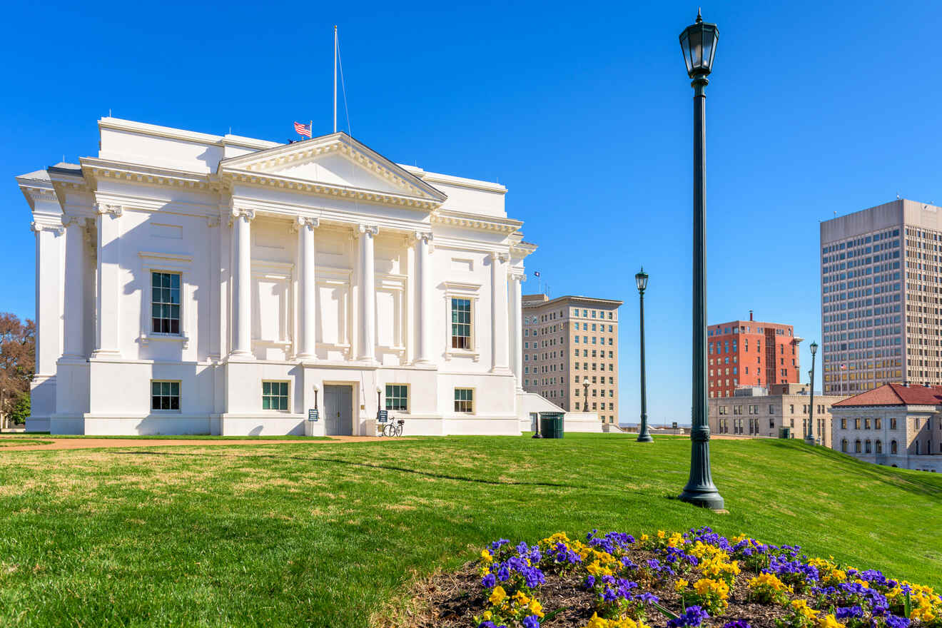 The historic Virginia State Capitol building with neoclassical architecture and vibrant flower beds in Richmond, Virginia