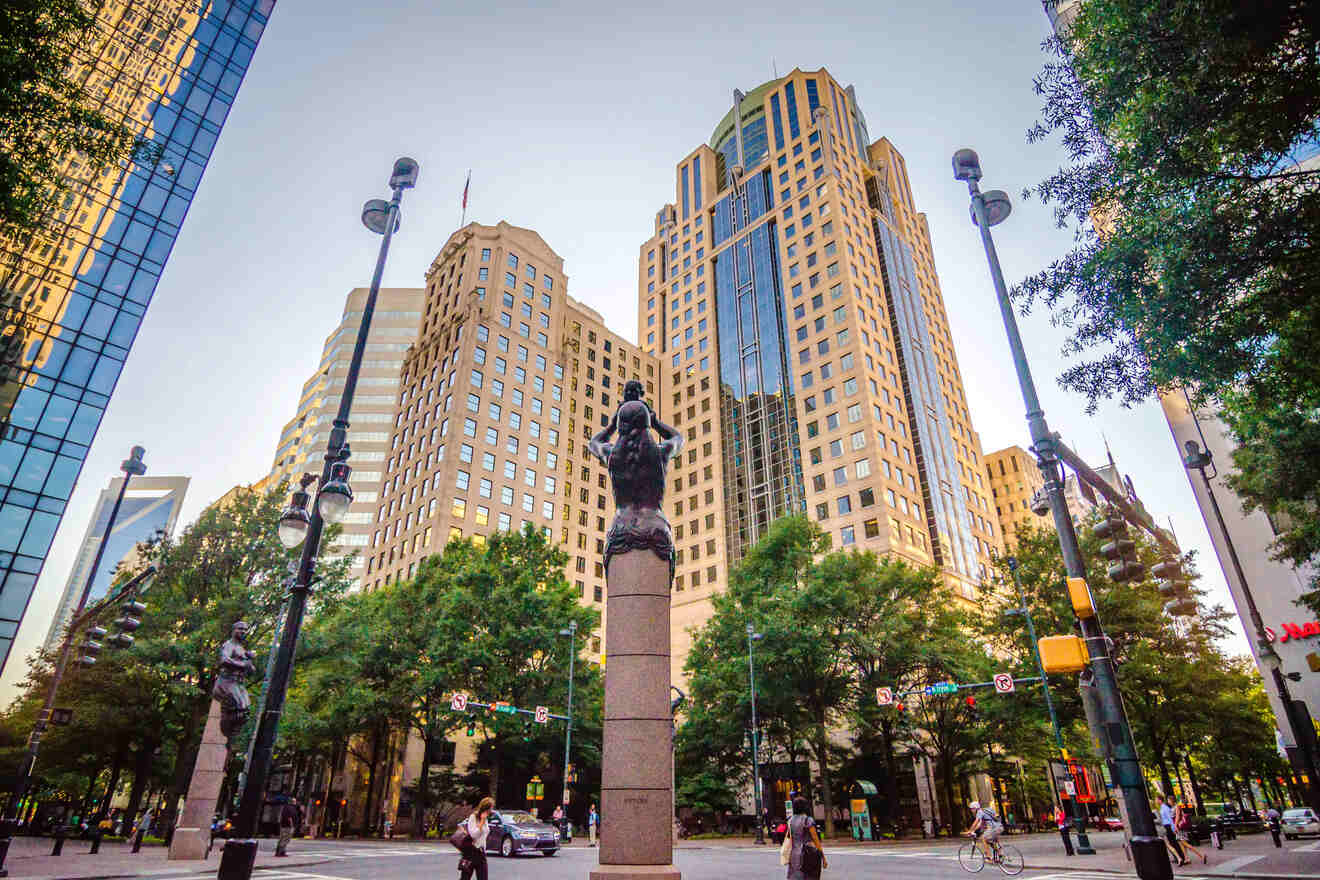 Street view of Uptown Charlotte with a sculpture in the foreground and high-rise buildings in the background