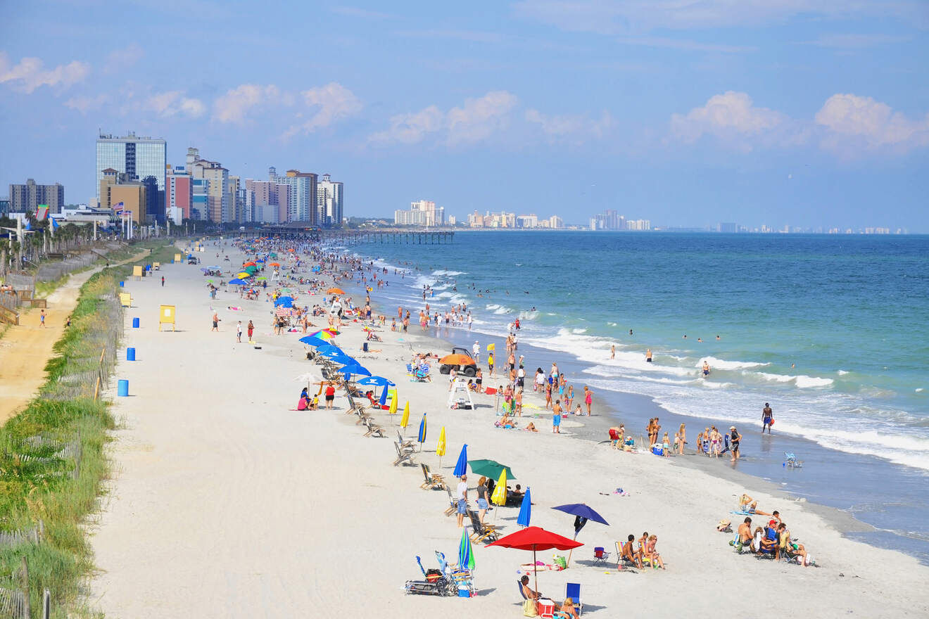 Aerial view of a bustling Myrtle Beach with colorful umbrellas and crowds enjoying the sandy beach
