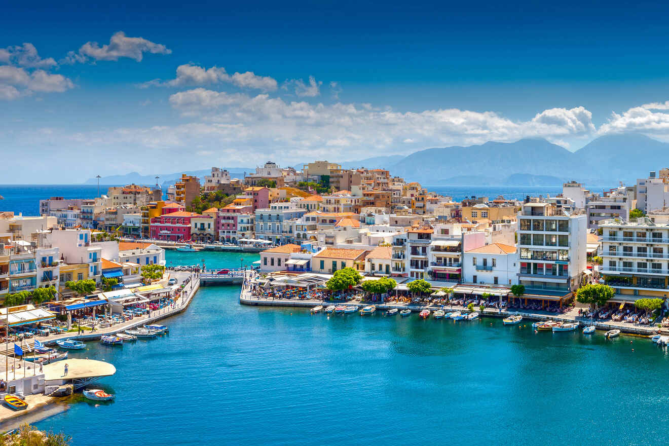 Aerial view of Agios Nikolaos port with colorful buildings and boats moored in Crete, Greece.
