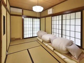 Classic Japanese tatami room with shoji sliding doors and futon bedding laid out