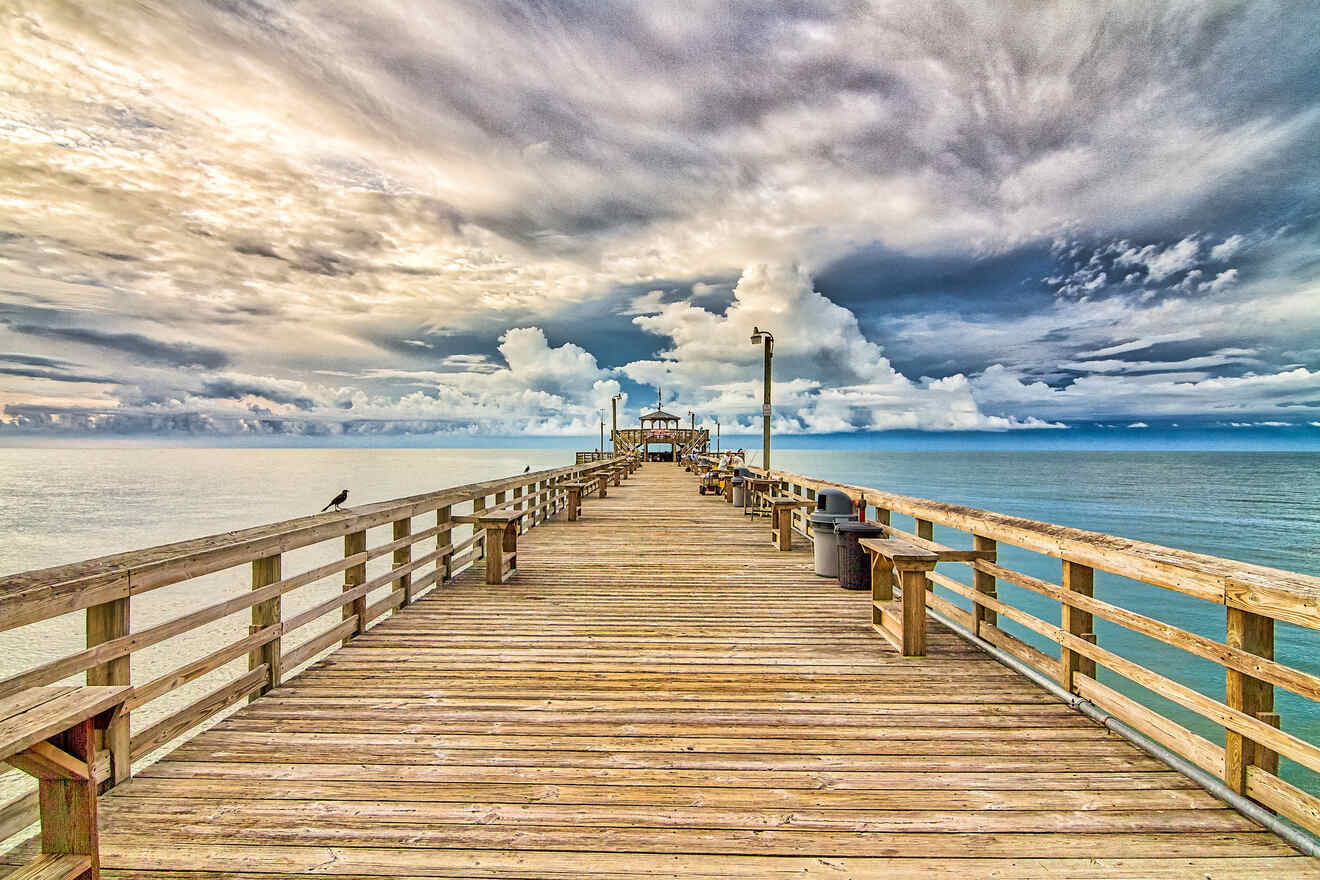 Dramatic clouds over a wooden pier at Myrtle Beach, with distant storm clouds over the ocean horizon