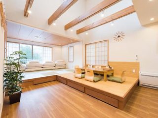 Bright and airy modern Japanese living space with tatami flooring, low wooden table, and floor seating against shoji screens