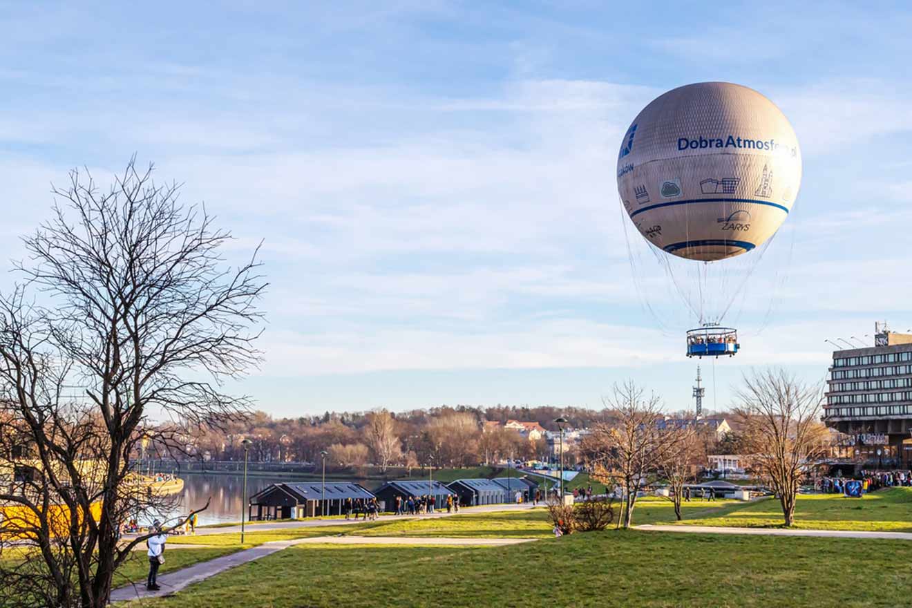 A hot air balloon flying over a park.