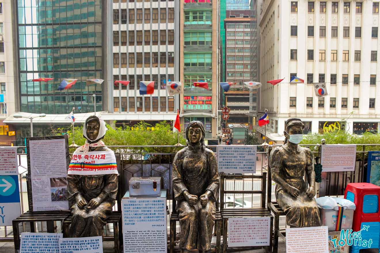 Statues covered in flags and scarves surrounded by signs explaining a protest as seen on a city walking tour, one of the best things to do in Hong Kong