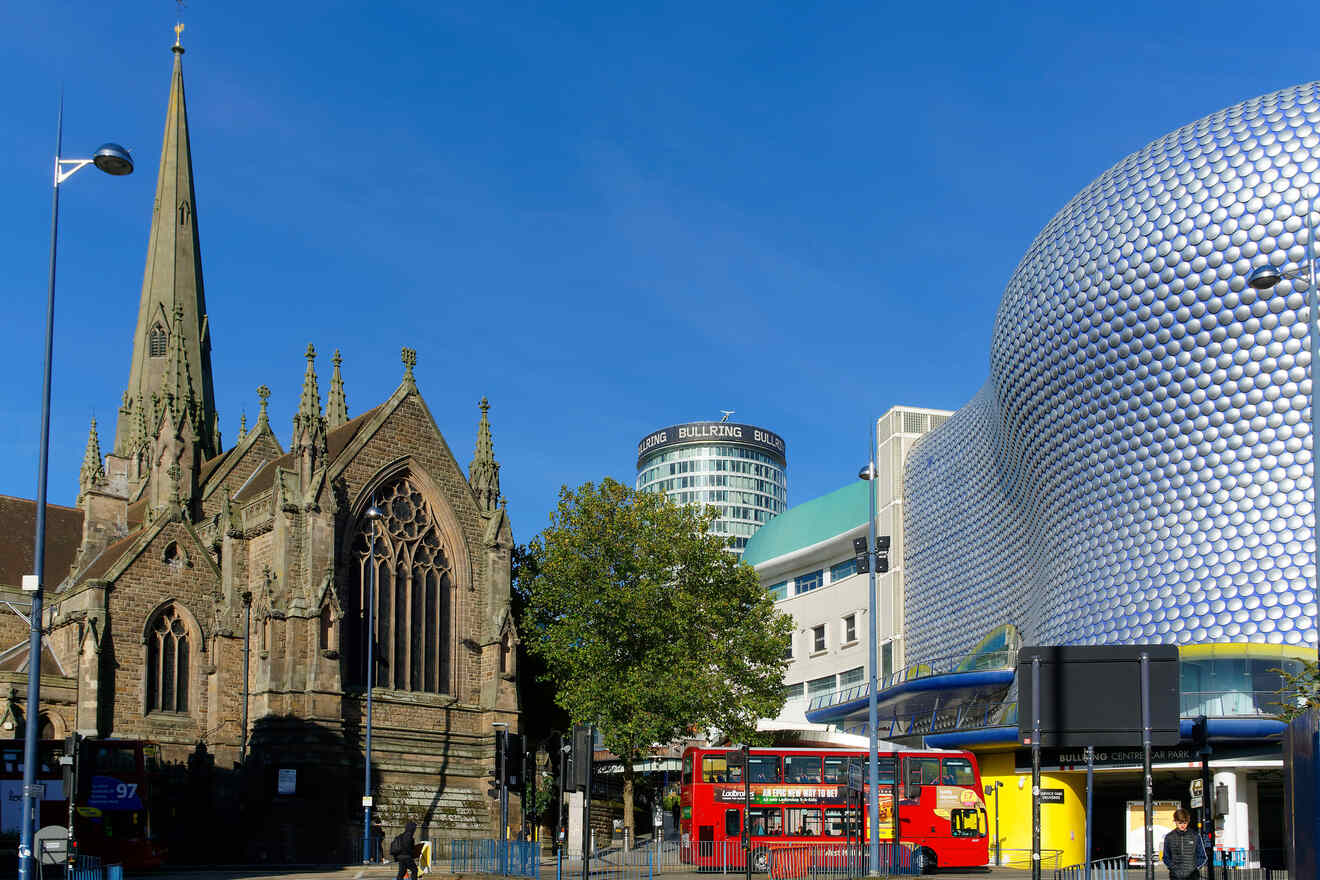 Cityscape featuring a historic church with a pointed spire, contemporary spherical architecture, and public buses on a sunny day