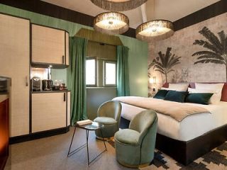 Boutique hotel room with a chic design, featuring a patterned accent wall, plush seating, and stylish lighting