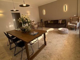 A stylish dining room in Bari, Italy, featuring a sleek table set against a backdrop of modern decor and natural light