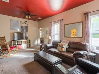 Cozy living room interior with a brown leather sofa, an entertainment unit, and a rocking chair,
