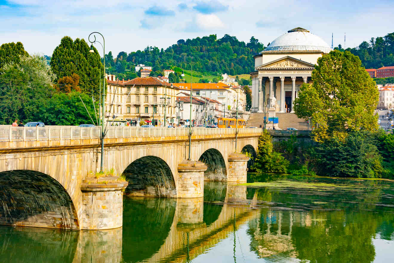 The Vittorio Emanuele I Bridge and Gran Madre di Dio Church in Turin, reflecting on the Po River on a sunny day.
