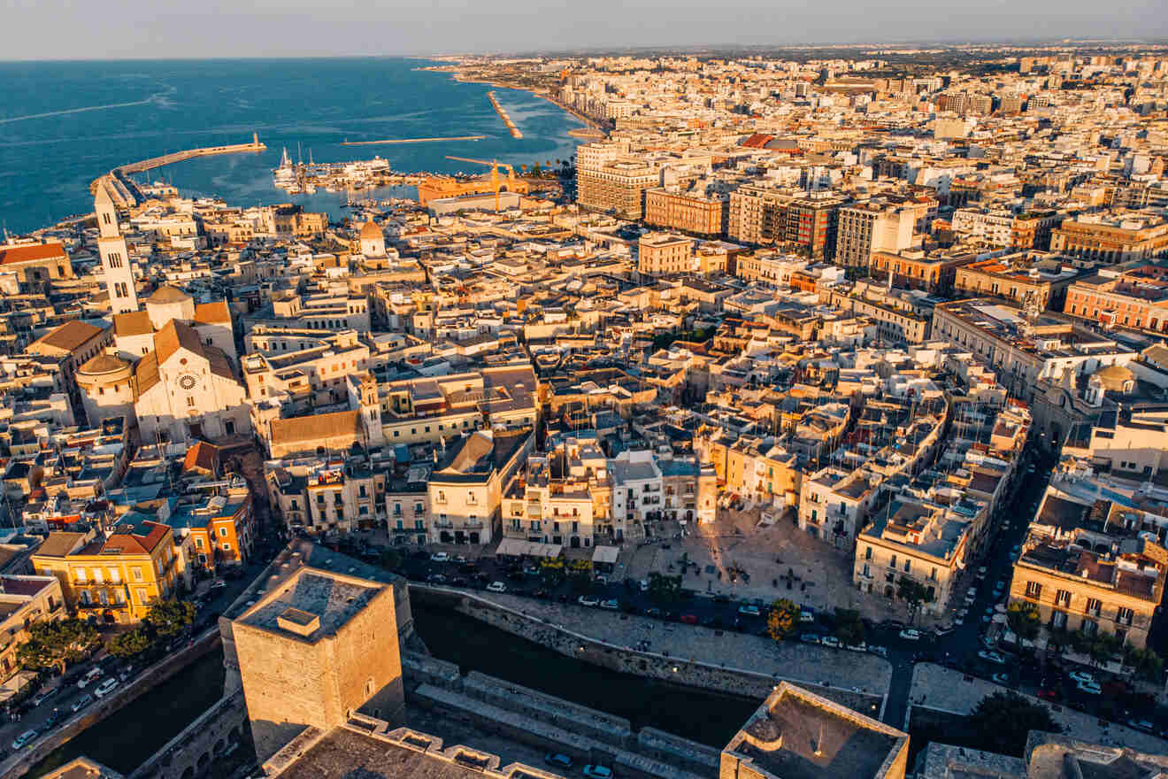 A breathtaking bird's-eye view of Bari, Italy, capturing the dense architecture, bustling streets, and the Adriatic Sea at sunset