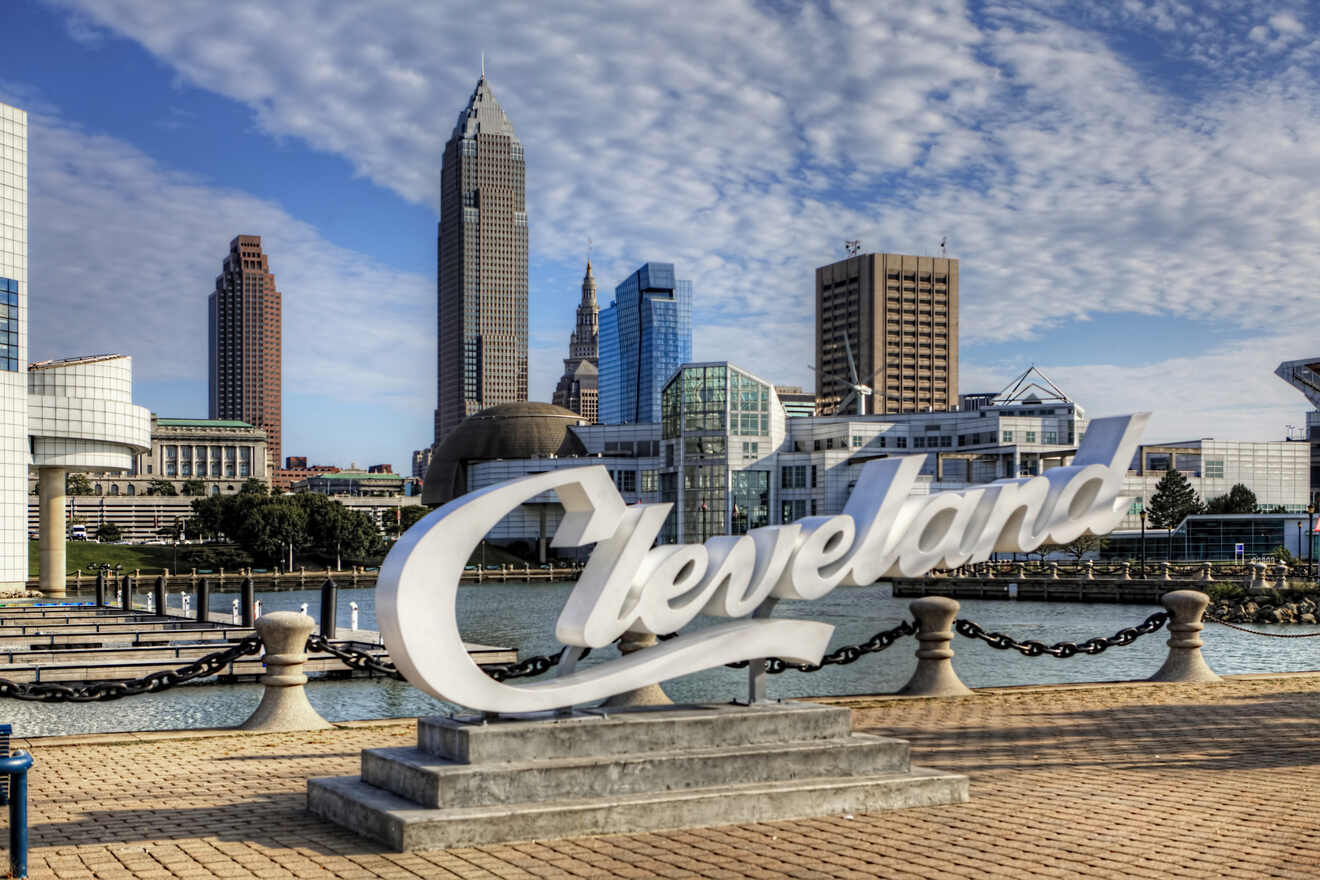 The Cleveland cityscape showcasing the iconic script "Cleveland" sign with skyscrapers and the Rock and Roll Hall of Fame in the background.