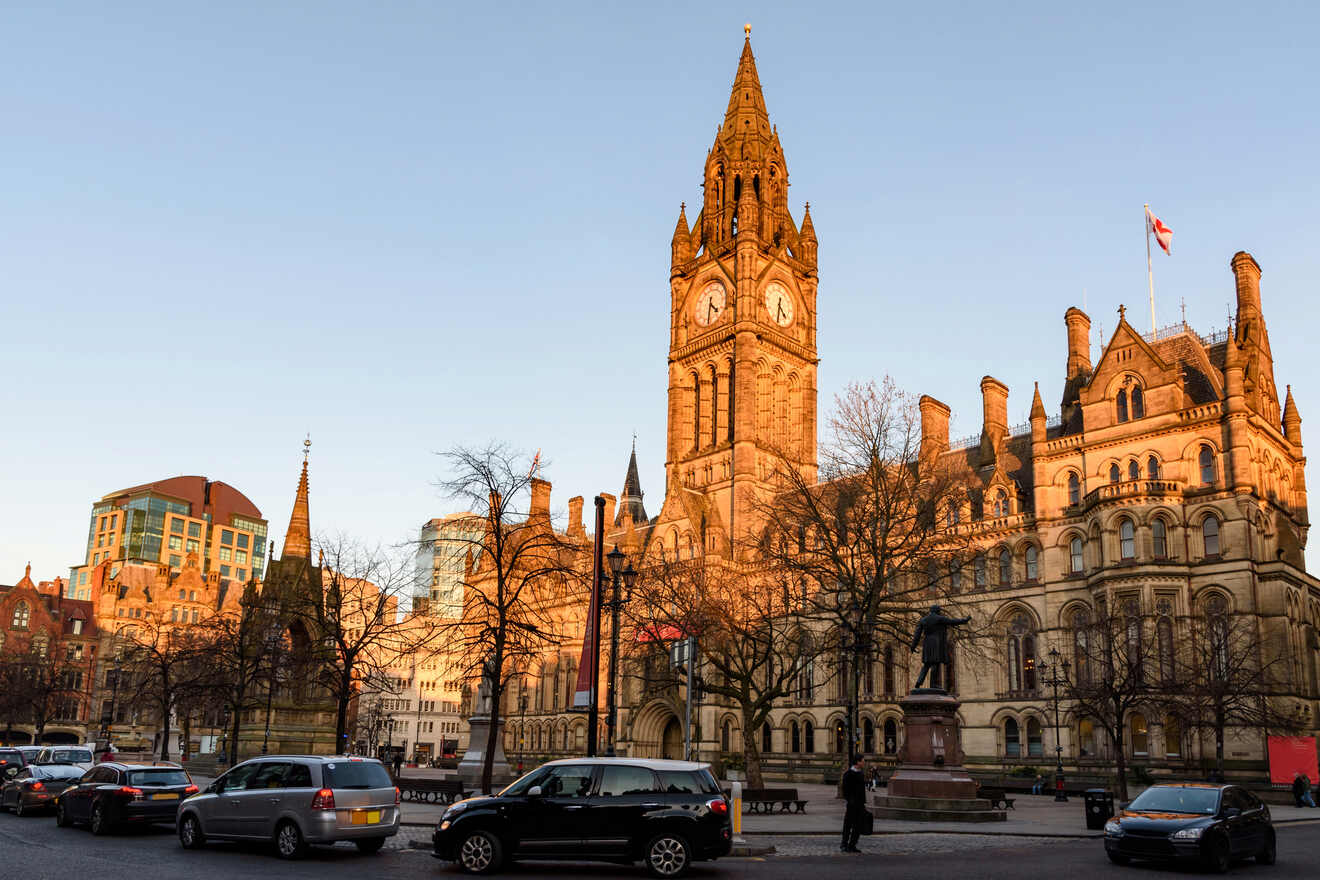 Twilight view of Manchester Town Hall's Victorian Gothic architecture, with the clock tower illuminated against the evening sky, and city life bustling in the foreground