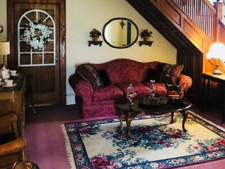 Vintage living room with a floral patterned sofa, wooden coffee table, and decorative stairway