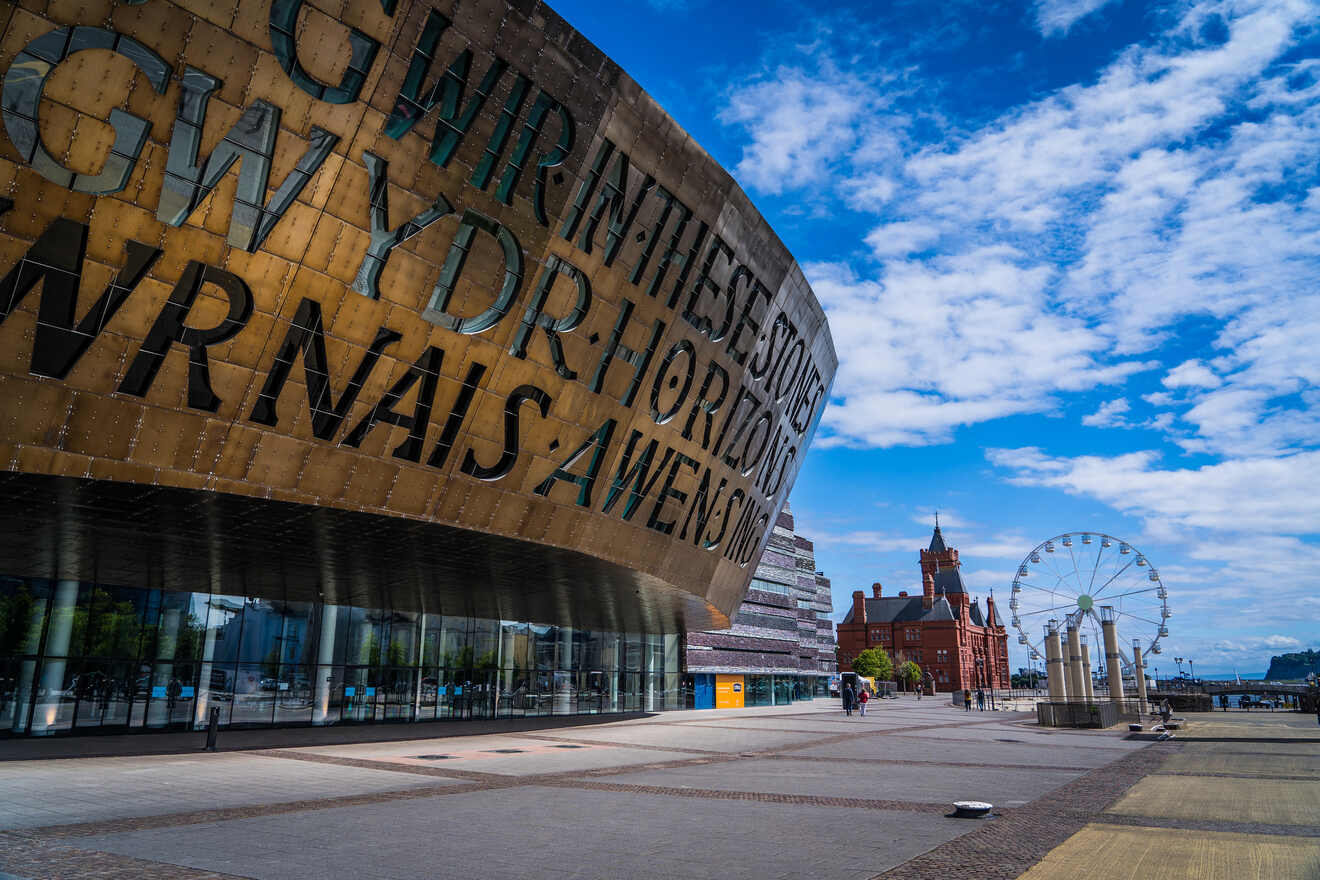 Close-up of the Wales Millennium Centre with its iconic inscription, set against a backdrop of clear blue skies and historical architecture