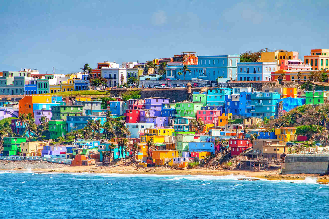 Colorful hillside buildings in a coastal town by the sea under a clear blue sky.