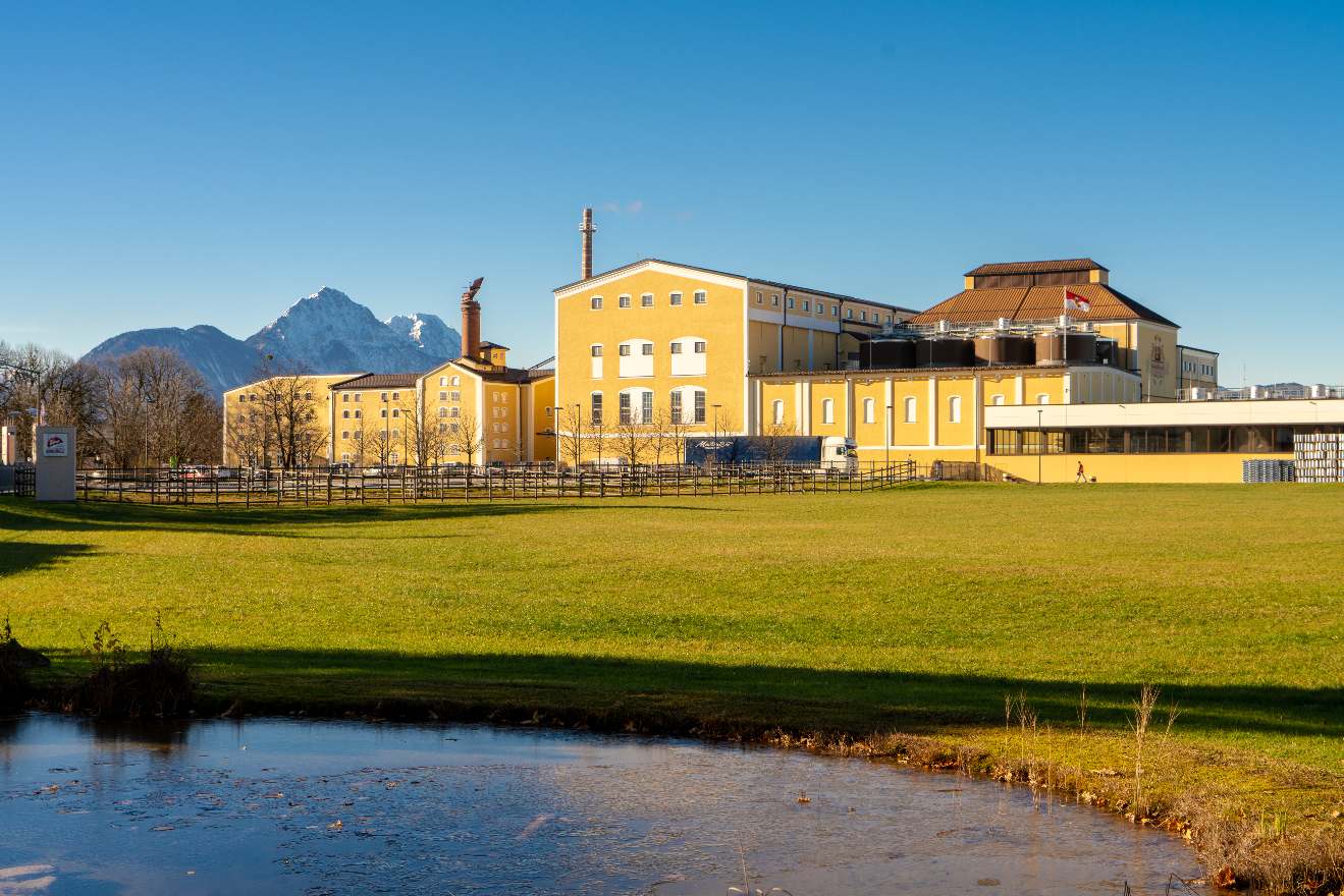 Exterior view of the Stiegl Brewery in Salzburg, Austria, with the Alps in the background