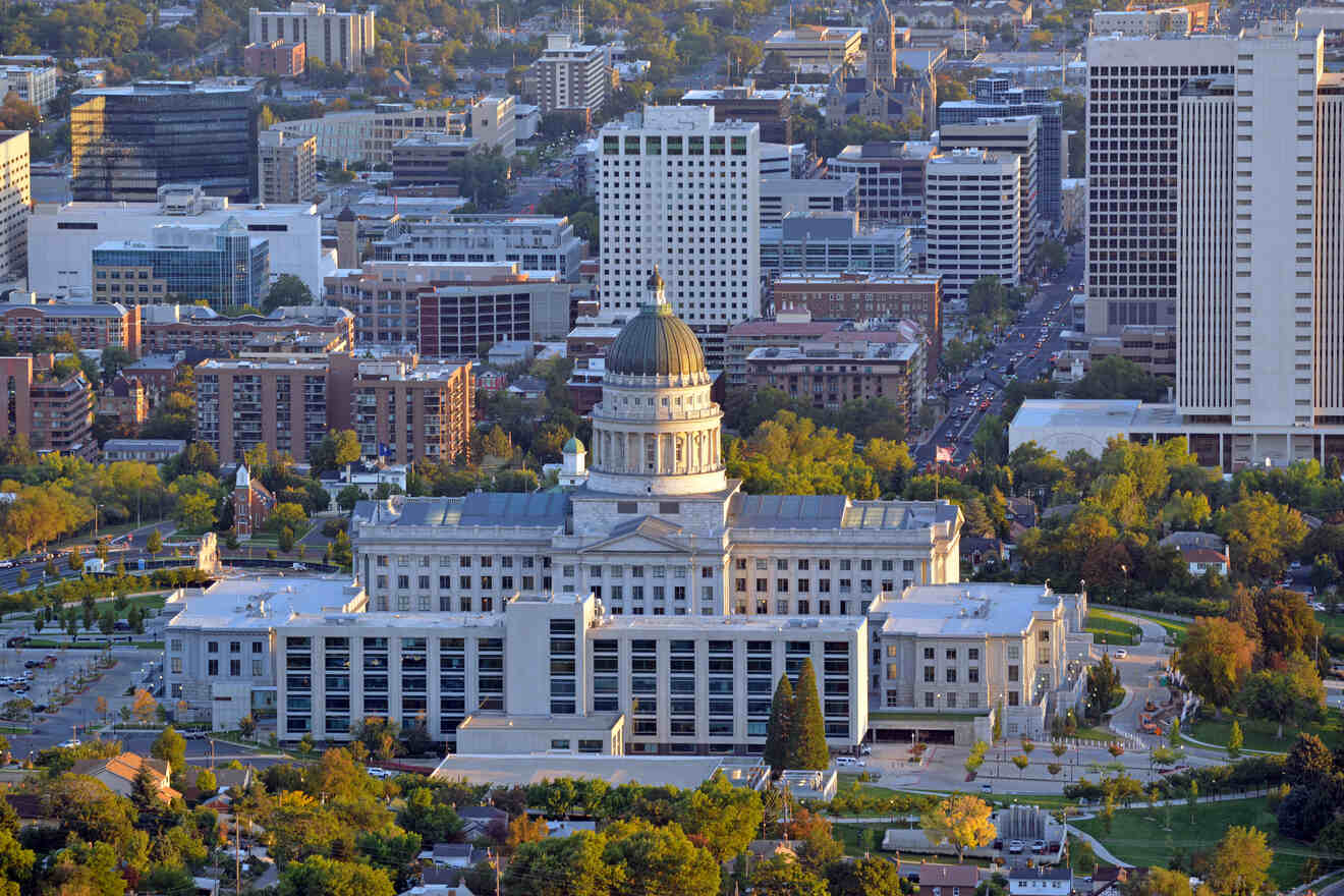 Aerial view of a large government building with a dome roof, surrounded by urban and greenery landscapes.