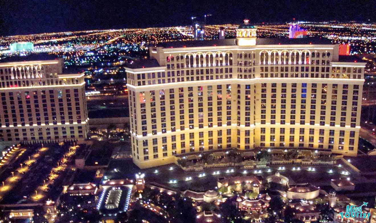 Nighttime aerial view of a lit-up Las Vegas hotel and the surrounding cityscape