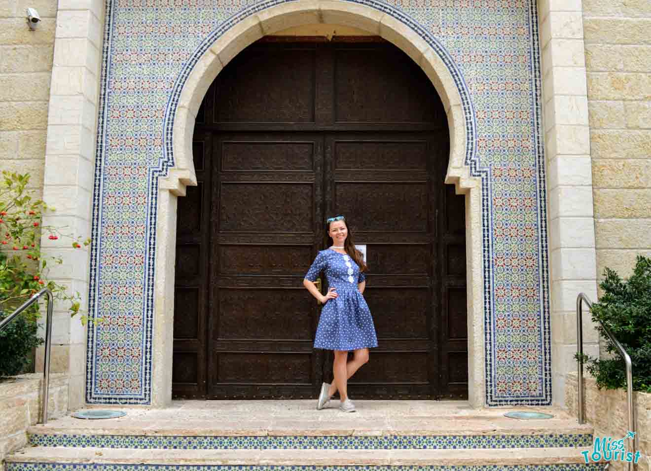 The author of this post posing in front of a traditional door with intricate blue and white tilework, exuding historic charm.