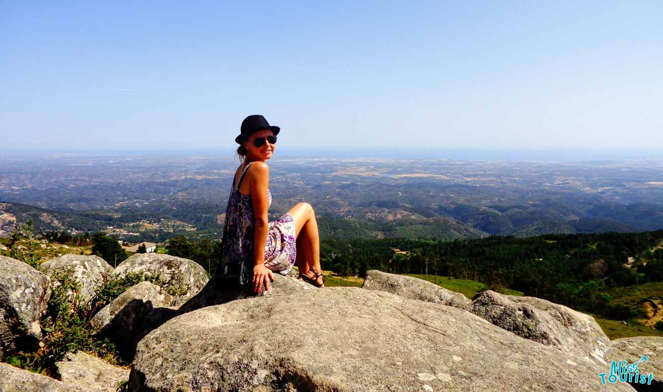 Yulia Saf, the writer of the post sitting on a rock offering panoramic view of the Algarve surroundings
