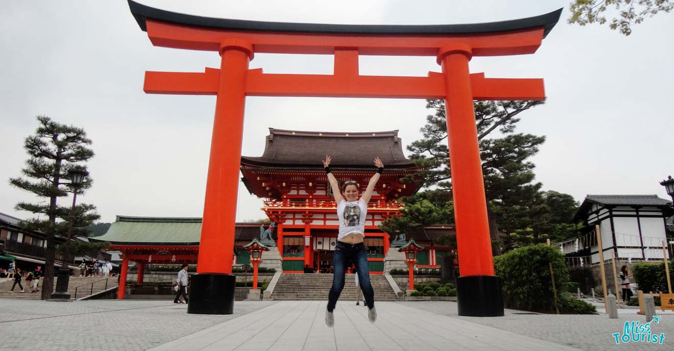 The writer of the post jumping in front of the vermilion torii gate at the Fushimi Inari Shrine in Kyoto, Japan