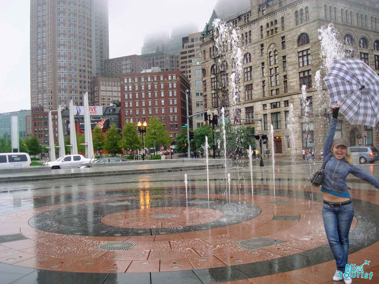 a girl holding an umbrella next to a fountain