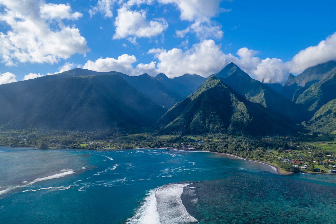 Aerial view of a stunning coastline with a mix of lush green mountains and a clear blue sea in Tahiti