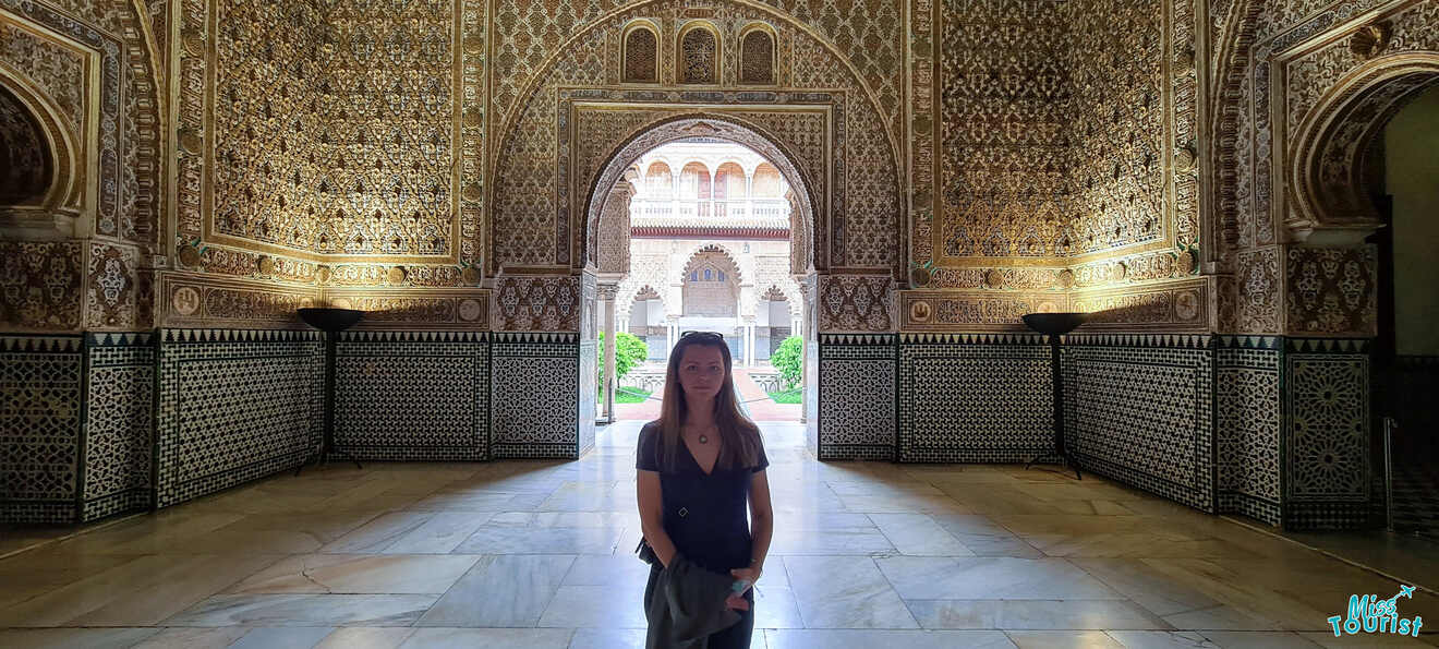 Visitor standing in the Hall of Ambassadors at the Real Alcázar of Seville, marveling at the stunning golden dome and intricate Islamic geometric patterns, a testament to the architectural grandeur of Andalusian heritage