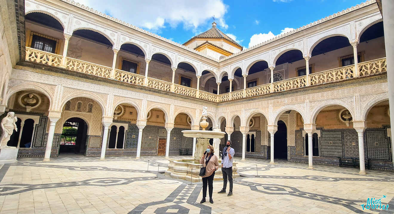 Two people standing in an ornate courtyard.