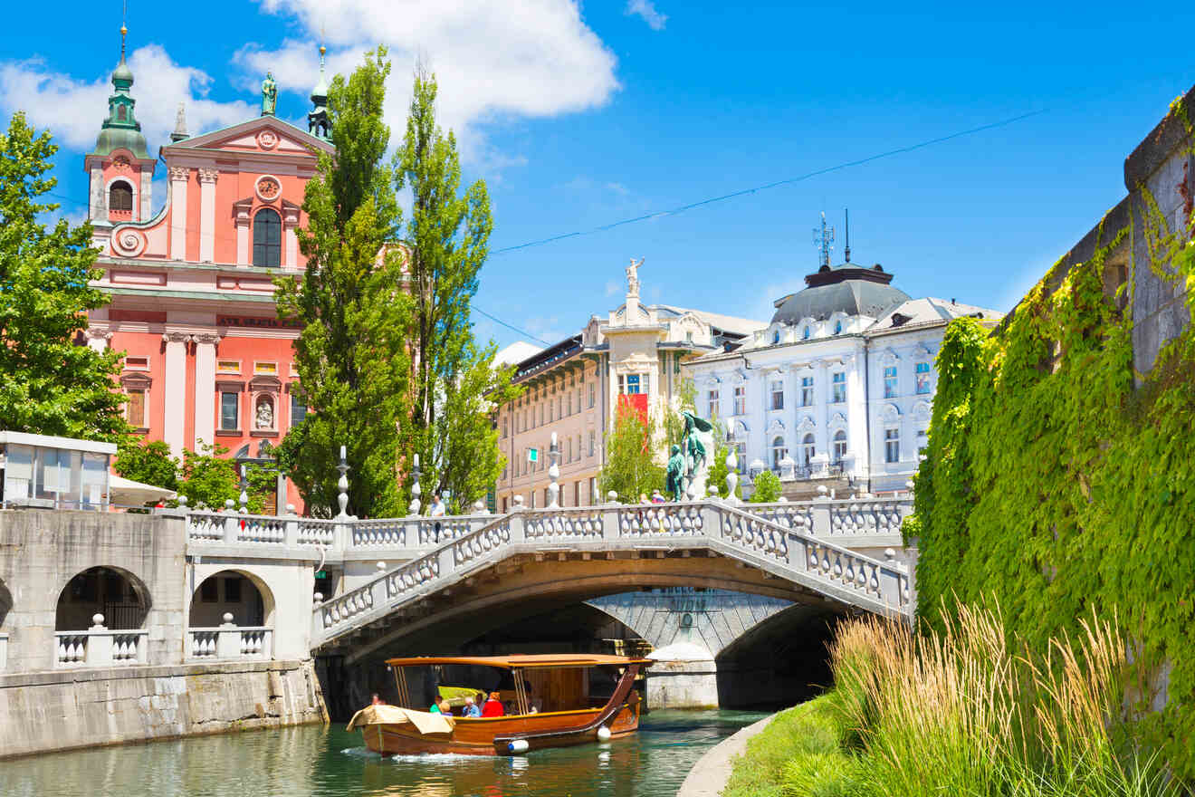 A scenic view of a colorful, historic European town with a boat on a river, a stone bridge, and vibrant buildings on a sunny day.