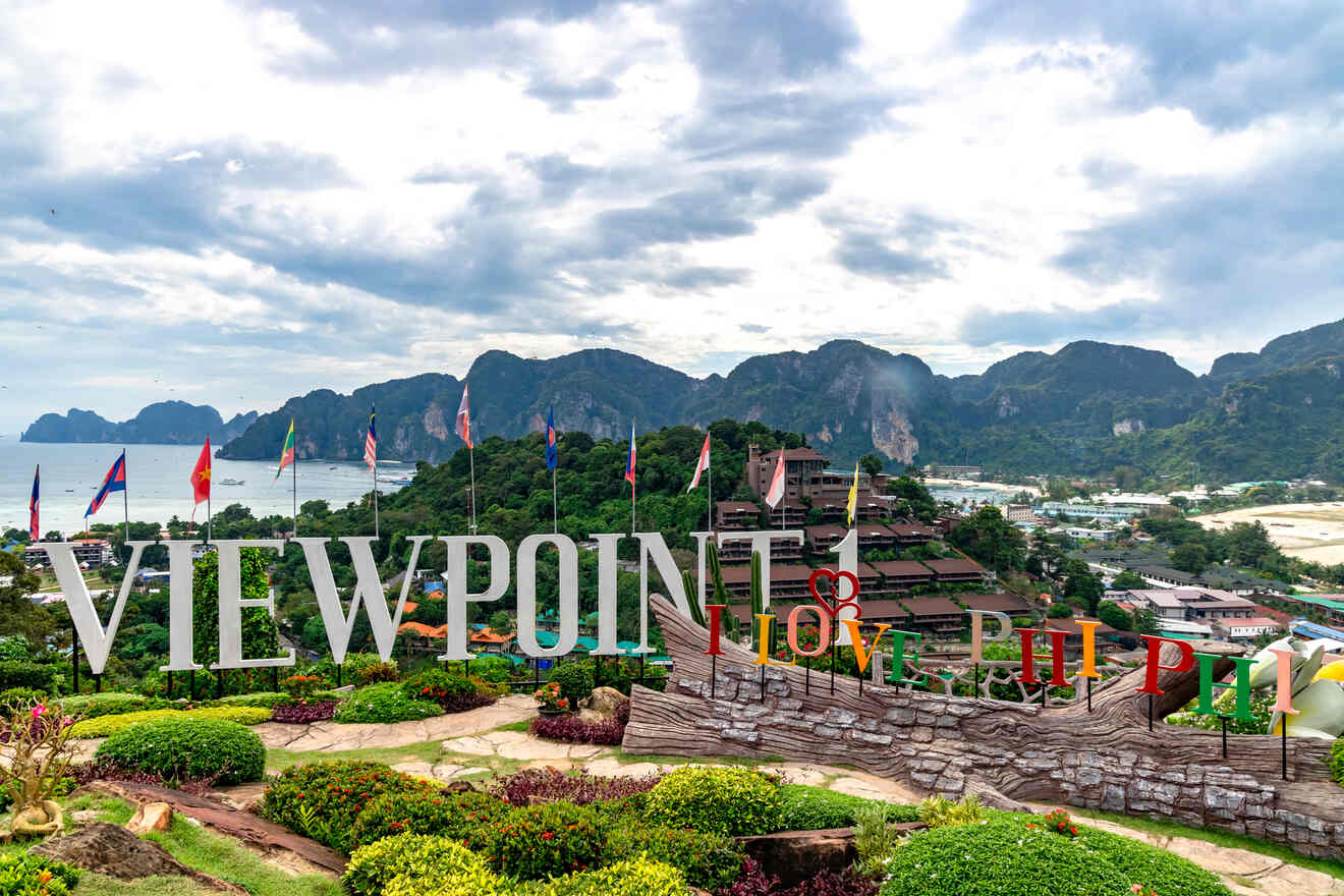 A panoramic viewpoint with a "VIEWPOINT" sign and flags, overlooking a scenic bay and mountains.