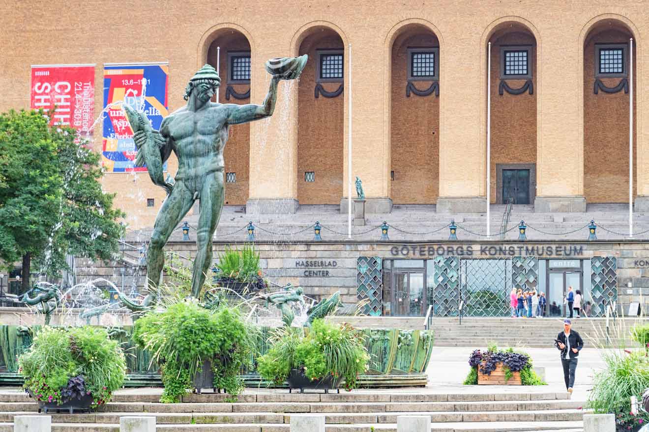 Statue of Poseidon in a fountain outside Gothenburg Museum of Art; banners hang on the museum's facade.