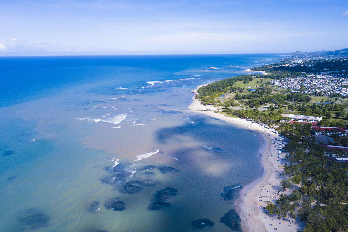 An aerial photo of a long beach comparing Puerto Plata vs. Punta Cana