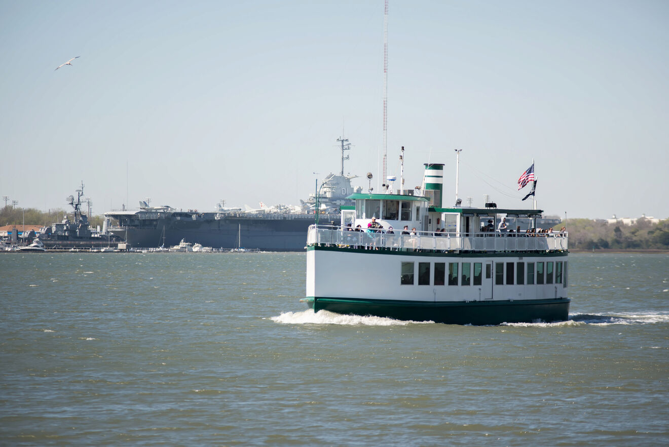 A boat with an American flag floats through the waters comparing Savannah Vs. Charleston for holidaymakers