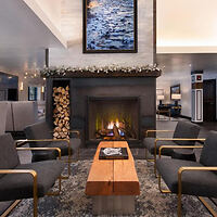 Luxurious hotel lobby with a central fireplace, modern art pieces, and designer furnishings