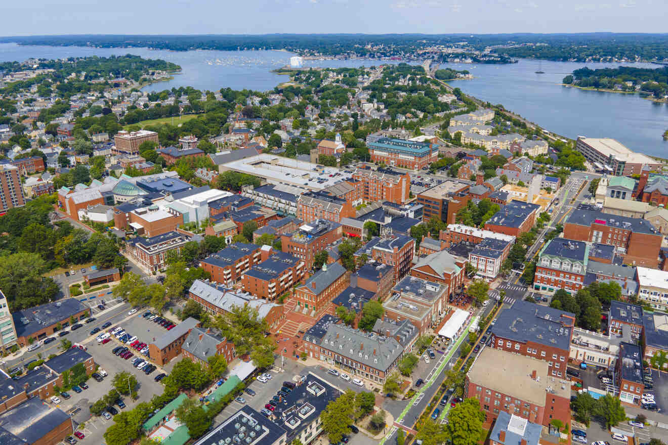 Aerial view of a coastal town of Salem with dense urban architecture, green spaces, and a wide river flowing into the ocean