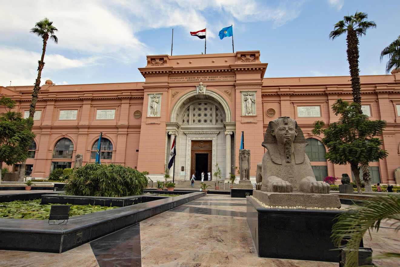 Front view of the Egyptian Museum with statues and flags at the entrance
