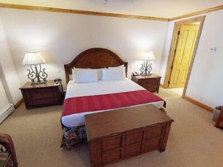 Hotel bedroom with a king-sized bed, traditional wooden furniture, and a warm color scheme