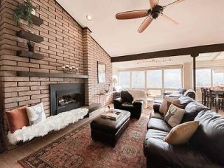 Cozy mountain resort living room with a brick fireplace, plush sofas, and a warm, inviting ambiance