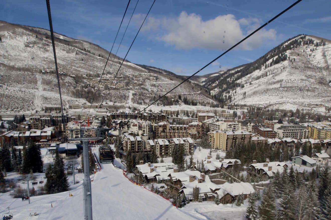 View from a ski lift in Vail overlooking a snow-covered ski resort and village with mountain scenery in the background