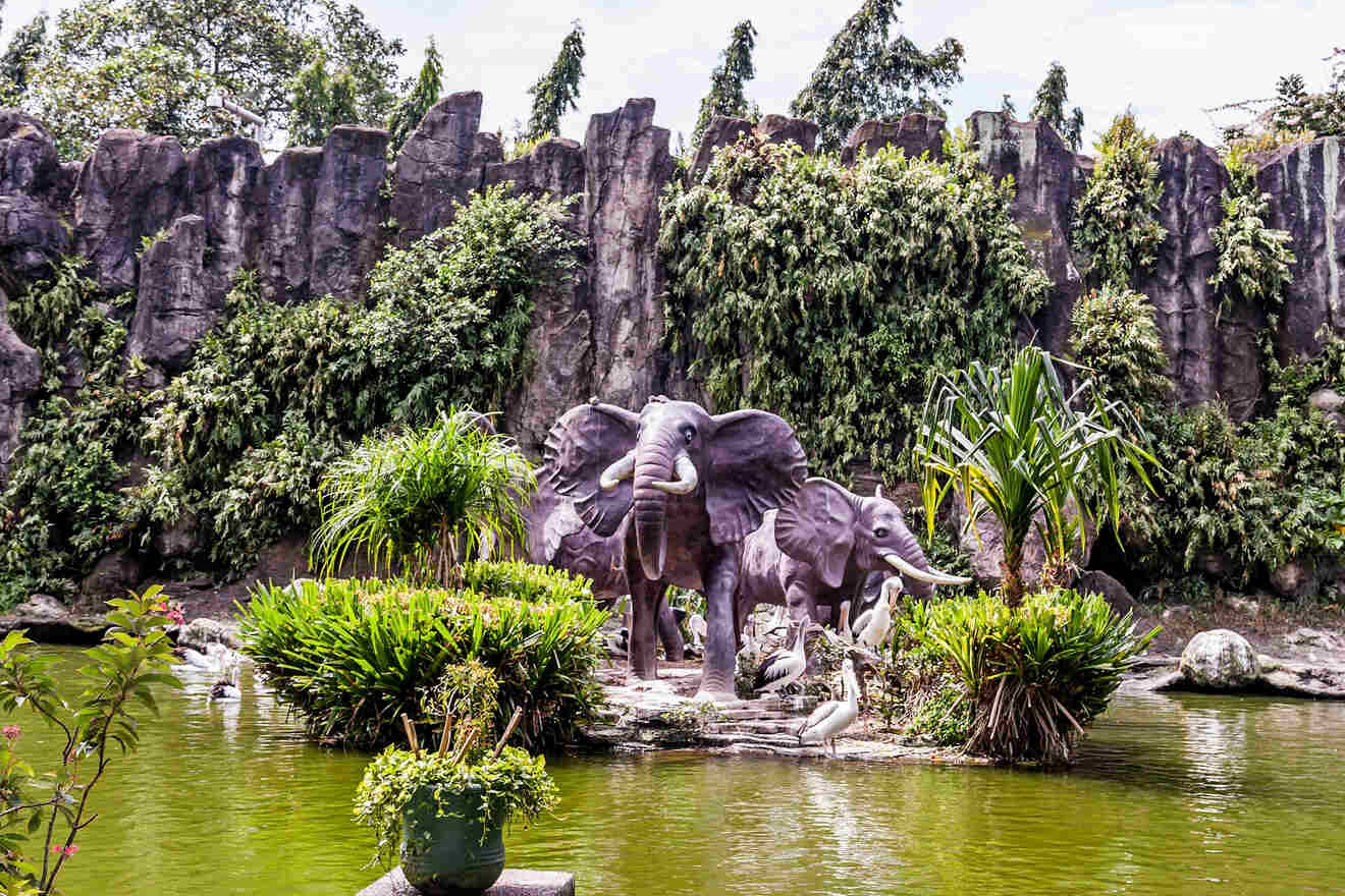 A peaceful garden scene with elephant statues surrounded by greenery and a small pond