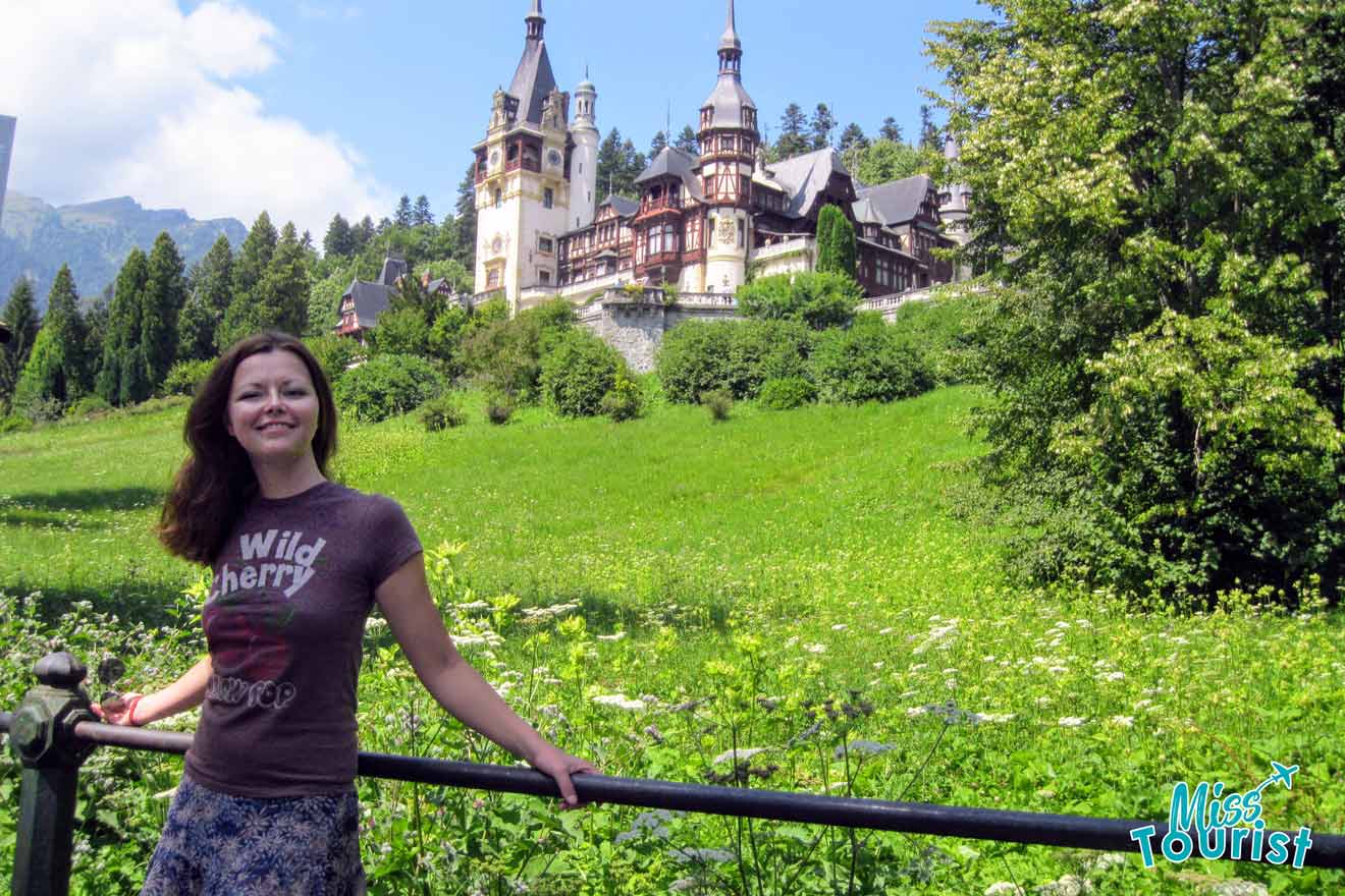 Yulia, the founder of this website, stands smiling in front of a scenic backdrop featuring a large, ornate castle surrounded by lush greenery.